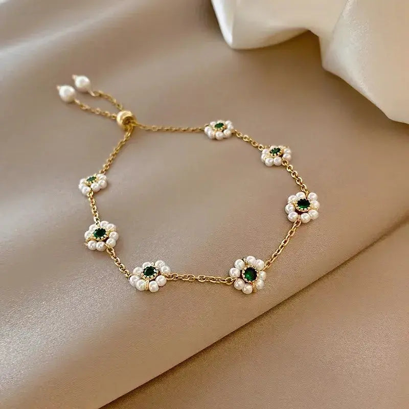 Elegantes Gänseblümchen-Armband mit grünen Kristallen